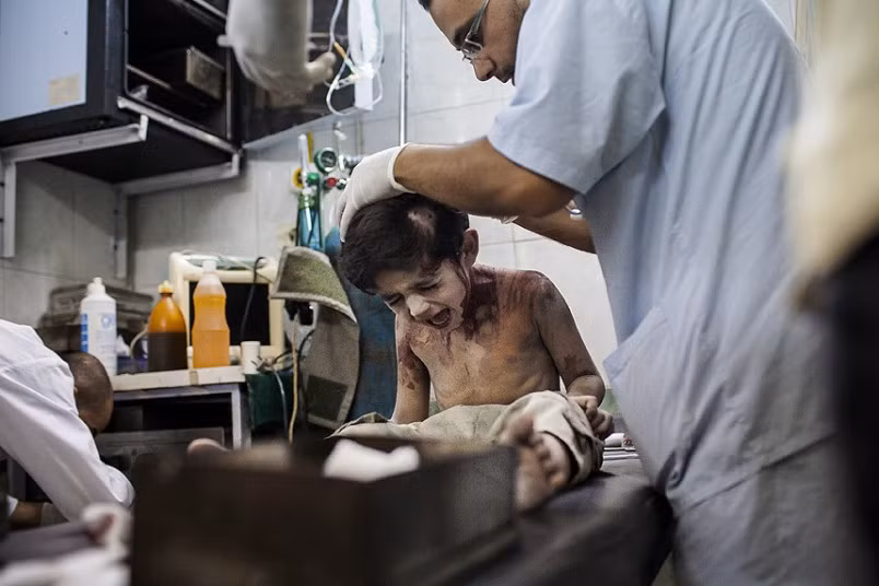 Bức ảnh bé trai đau đớn vì bị thương nặng trong một cuộc không kích tại khu phố Sha'ar của thành phố Aleppo ngày 24/8/2012 của Nhiếp ảnh gia Nicole Tung. Nhiếp ảnh gia chia sẻ: “Bé trai bị trúng một mảnh bom và may mắn giữ được tính mạng. Thật đau lòng khi chứng kiến những đứa trẻ ngây thơ, vô tội trở thành nạn nhân của chiến tranh. Qua bức ảnh, tôi muốn nhấn mạnh rằng, trẻ em không chỉ là đối tượng dễ bị tổn thương nhất mà còn vô cùng kiên cường và dũng cảm...”.