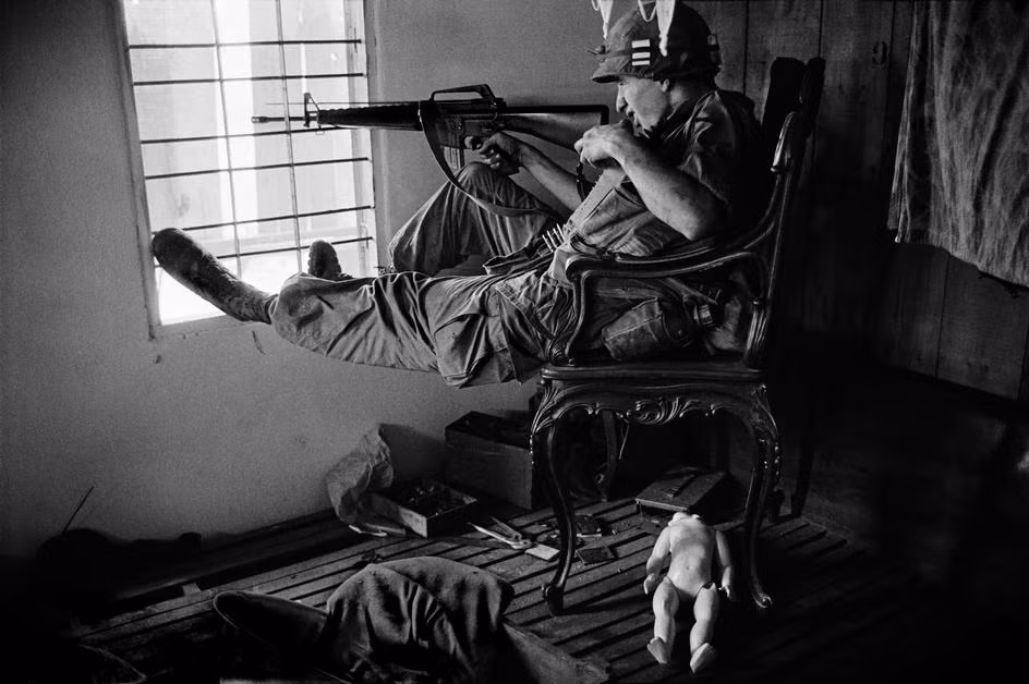 Lính bắn tỉa Mỹ ngắm bắn trong ngôi nhà bỏ hoang ở Sài Gòn năm 1968. Ảnh: Philip Jones Griffiths/Magnum.