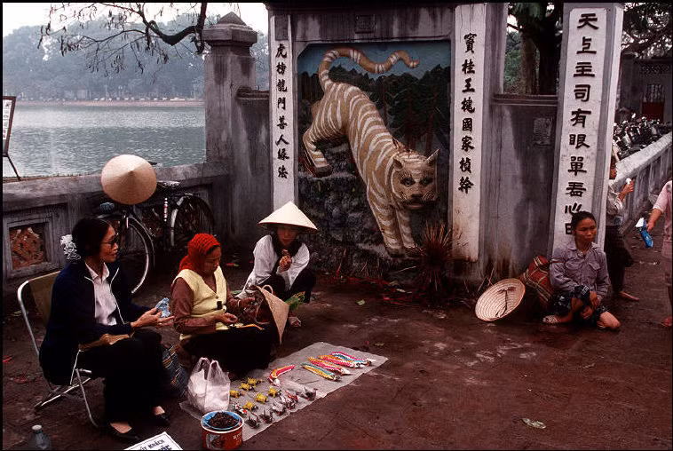 Quầy bán đồ chơi bằng giấy ngoài cổng đền Ngọc Sơn. Ảnh: Bruno Barbey/Magnum.