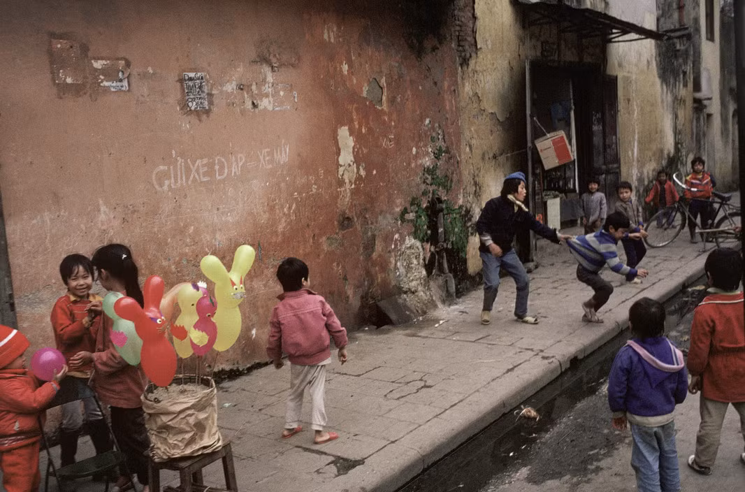 Trẻ em chơi đùa ở khu phố cổ ngày Tết. Ảnh: David Alan Harvey/Magnum.