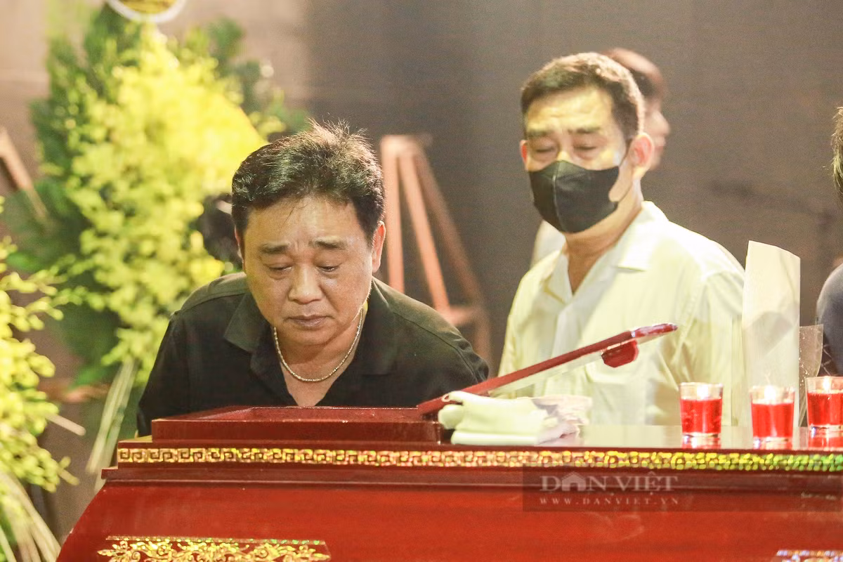 NSND Quốc Khánh, người nghệ sĩ gắn liền với vai diễn "Ngọc Hoàng" trên màn ảnh, lặng lẽ nhìn mặt người đồng nghiệp thân thiết lần cuối, không giấu nổi niềm xúc động trước sự ra đi quá sớm của NSƯT Bùi Phương Nga.