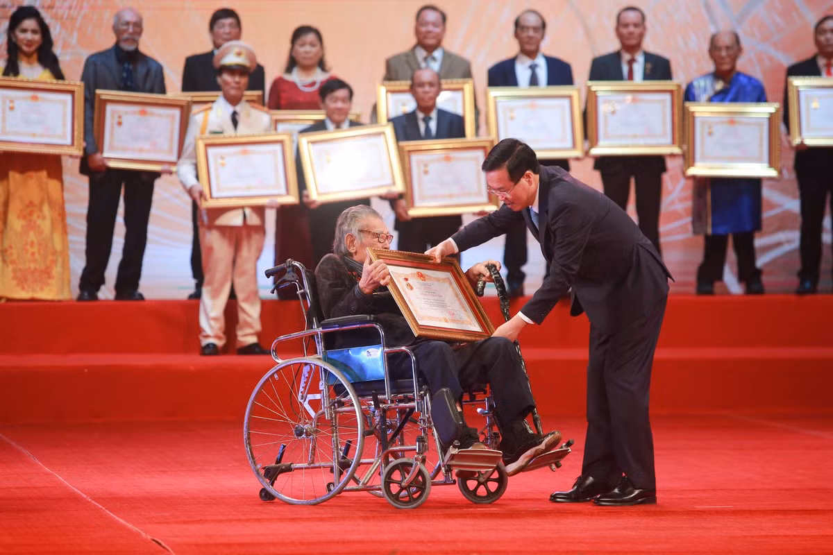 Nghệ sĩ Hoàng Qân Tạo - nguyên Giám đốc Nhà hát Kịch Hà Nội di chuyển bằng xe lăn đến nhận danh hiệu Nghệ sĩ Nhân dân cao quý.