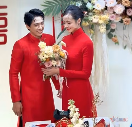  Hoa hậu Kiều Ngân và Tronie Ngô hạnh phúc, rạng rỡ trong ngày trọng đại. Cặp đôi diện áo dài đỏ nổi bật, thiết kế kiểu truyền thống. Trước sự chứng kiến của gia đình, bạn bè thân thiết, cả hai xúc động, trao nhau ánh mắt, cử chỉ ngọt ngào.