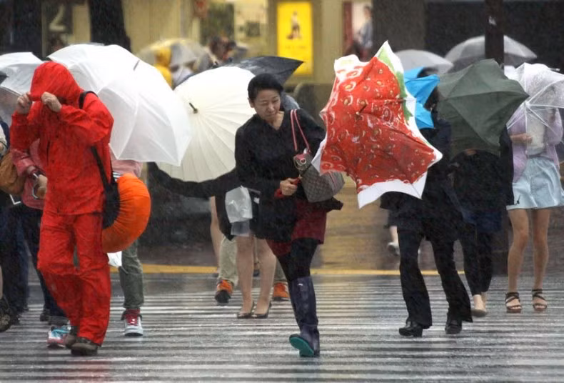 Mọi người đi dưới mưa và gió lớn ở Tokyo.