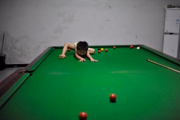 Thần đồng bi-a 3 tuổi chơi trên bàn trong giờ nghỉ.