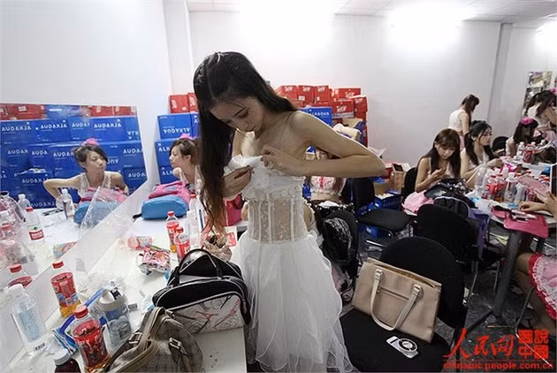 Quần áo đồng phục không vừa khít với người. Cô phải ghim lại để tránh sự cố tuột váy trong lúc nhảy múa, lắc mình.
