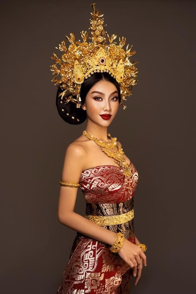 Cách đây không lâu, nàng hậu sinh năm 1998 có cơ hội diện trang phục truyền thống của Indonesia. Trang phục có chất vải họa tiết độc đáo mang đậm dấu ấn dân tộc. Điểm nhấn bộ cánh là chiếc mấn dát vàng ròng được chạm khắc tỉ mỉ. Nhìn vào phụ kiện, người hâm mộ cũng cảm nhận được sức nặng của nó đối người mặc. Dù vậy, đương kim MGI vẫn tự tin diện bộ cánh khó nhằn.
