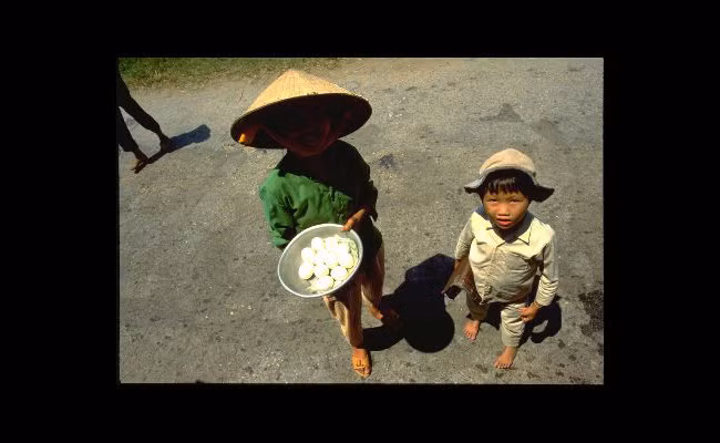 Hai em bé bán trứng luộc.
