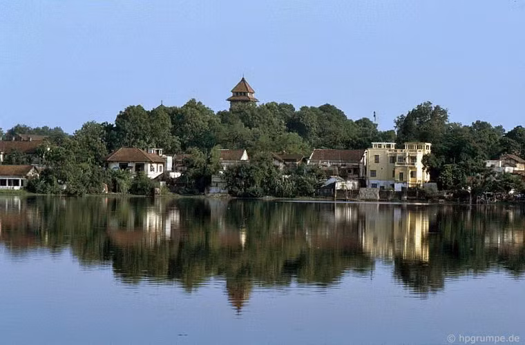 Tháp chuông nhà thờ Cửa Bắc cùng những ngôi nhà ven hồ Tây soi bóng xuống mặt nước.