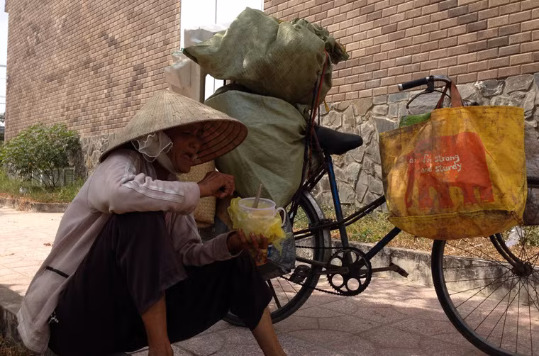 Sáng 30 Tết, không khí tết tràn ngập mọi nhà khi thời khắc giao thừa gần kề. Ở một góc đường nhỏ gần khu tái định cư Khu công nghệ cao phường Tăng Nhơn Phú A, quận 9, TP HCM, bà Hai (76 tuổi, quê ở Trà Vinh) vẫn lầm lũi dừng chiếc xe đạp chất đầy "chiến lợi phẩm" vừa thu lượm được, rồi lấy hộp nhựa đựng cơm ra ăn. "Tết cũng thèm về sum họp với con cháu nhưng tốn kém lắm, nên tui đành ở lại.", bà Hai chia sẻ.