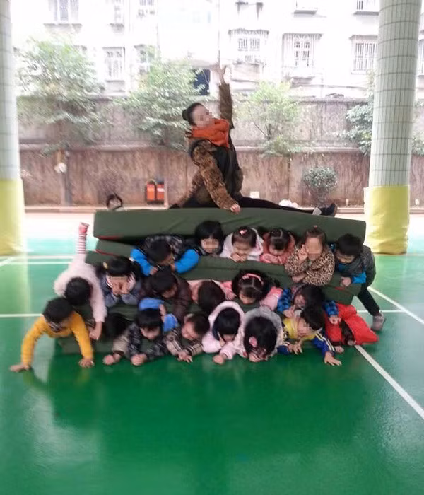 Bức ảnh mô tả cảnh một cô giáo của một trường mẫu giáo ở Hồ Nam (TQ) thoải mái tạo dáng khi ngồi lên người của khoảng 20 học sinh bị kẹp giữa những tấm đệm cũng từng gây bức xúc dân mạng vào cuối năm ngoái. Nhà trường giải thích rằng đây chỉ trò chơi chồng xếp có tên là "Hamburger", một trong những hoạt động phổ biến tại các trường học ở Trung Quốc, tuy nhiên một chuyên gia y tế đã đưa ra những lời cảnh báo về trò chơi nguy hiểm này.