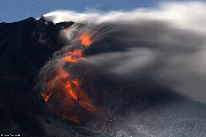 Cảnh tượng huyền ảo tạo bởi dòng dung nham và khói bụi trên núi Sinabung. Ảnh: Ivan Damanik.