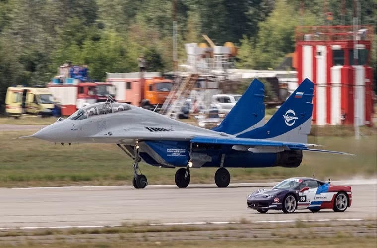 Trong ảnh là một chiếc tiêm kích MiG-29 đang thực hiện màn đua tốc độ với mẫu xe Ferrari 458 Italy, trong khuôn khổ các hoạt động trình diễn ngoài trời trong triễn lãm Oboronexpo-2014.