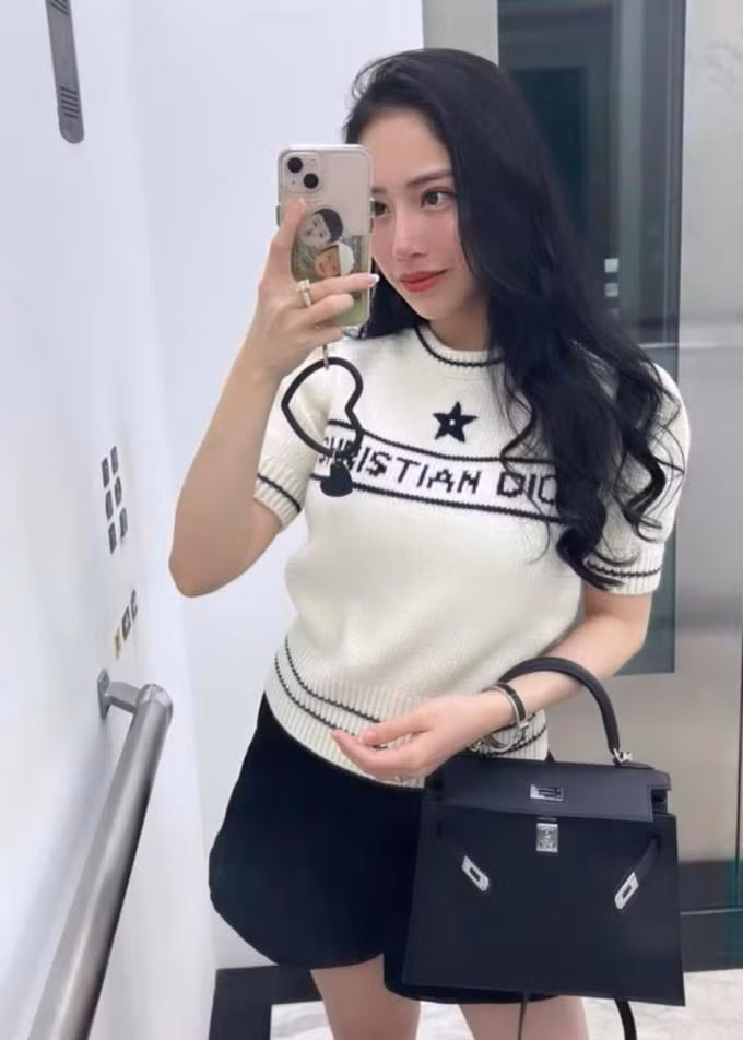 Joyce Phạm khoe outfit ra phố trông đơn giản nhưng có tổng giá đến nửa tỷ đồng. Bà mẹ hai con mặc áo len ngắn tay của Dior kết hợp túi xách Hermes Kelly và vòng tay cùng thương hiệu. Trang phục tông đen trắng giúp con gái Minh "Nhựa" tôn dáng thon gọn dù mới sinh bé thứ hai cách đây không lâu.