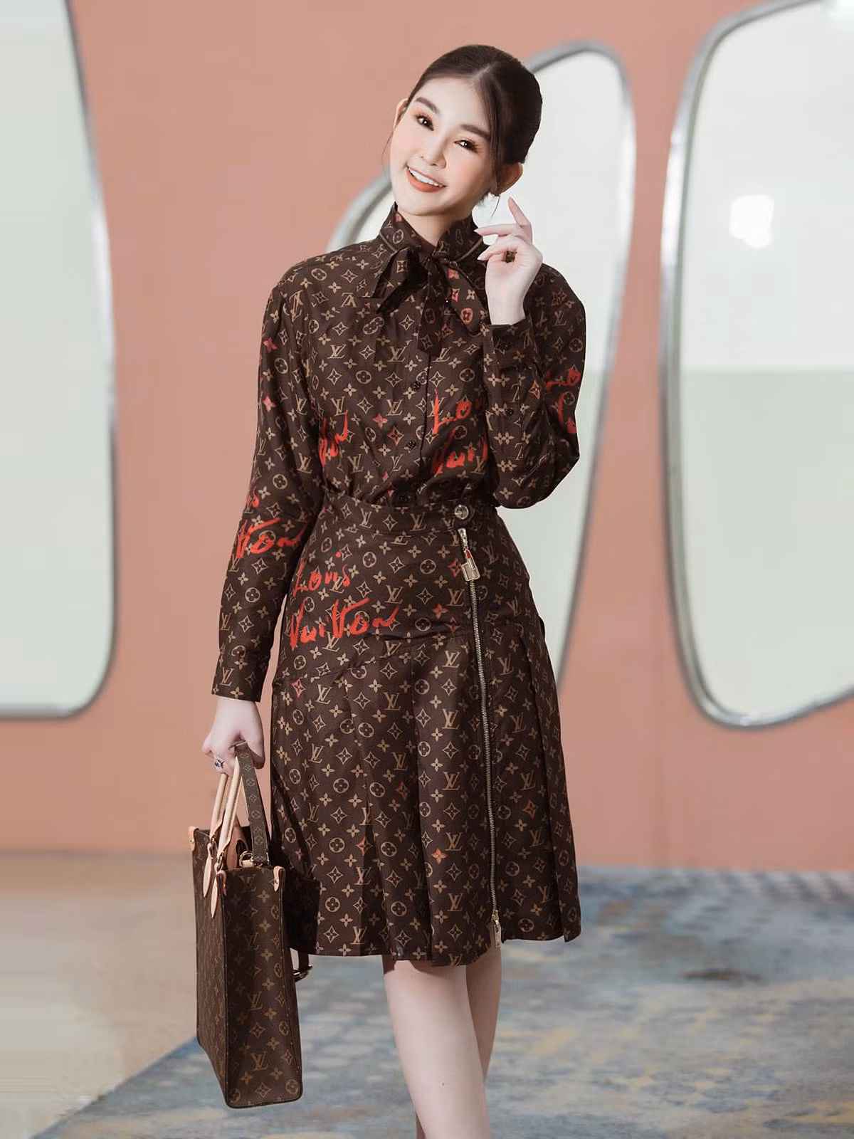 Bộ váy áo họa tiết monogram được nàng hậu kết hợp cùng túi Sac Plat 2.640 USD (63 triệu đồng).