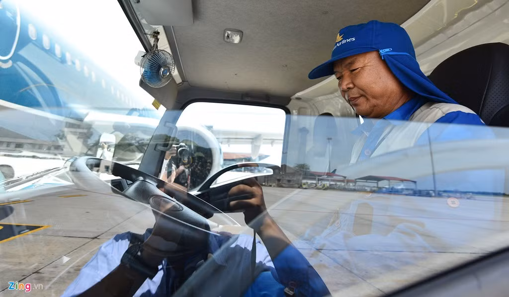 Nhiều nhân viên lái xe đầu kéo, xe tải, xe nâng phải dùng khăn ẩm trùm lên đầu rồi đội mũ để chống chọi với nắng nóng.