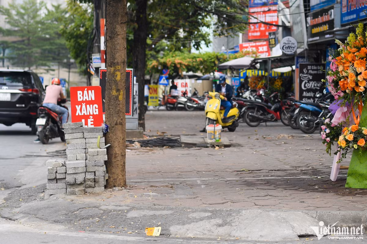 Trên nhiều tuyến phố như Tôn Đức Thắng, Cát Linh, Trịnh Hoài Đức người đi đường không khó bắt gặp những trạm xăng “di động”. Một hộ kinh doanh hoa cũng tranh thủ treo biển bán xăng lẻ.