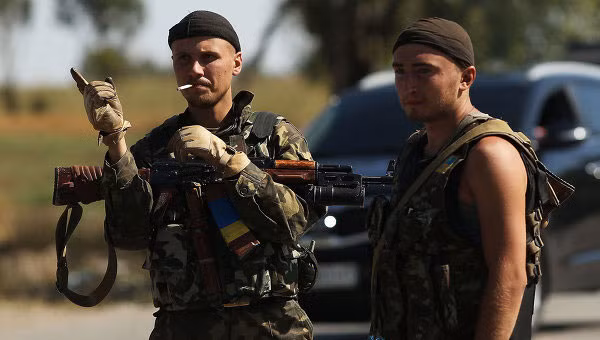 Hai thành viên vũ trang đứng canh gác ở một trạm kiểm soát ở miền đông Ukraine.
