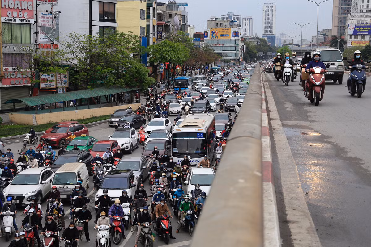 Phía dưới cầu vượt, hàng dài xe cộ xếp hàng chờ đèn tín hiệu.