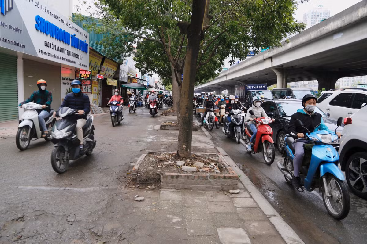 Người đi xe máy lao lên vỉa hè để thoát khỏi cảnh xếp hàng phía sau trên tuyến đường này.
