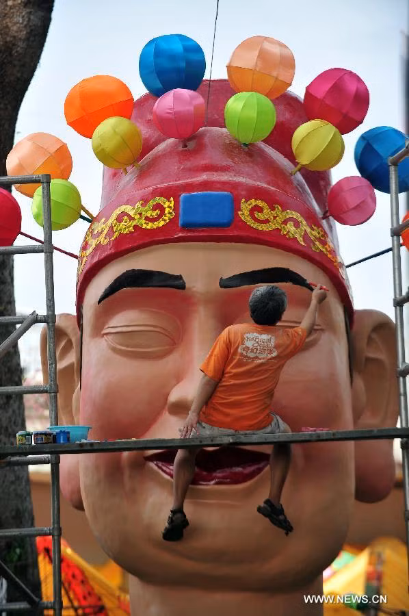Trong khi đó, ở Singapore, công việc chuẩn bị đón Tết Nguyên đán cũng bắt đầu rục rịch. Trong ảnh, một thợ thủ công đang vẽ lông mày cho chiếc đèn lồng hình Thần tài khổng lồ cho dịp tết. Ảnh chụp ngày 10/1.