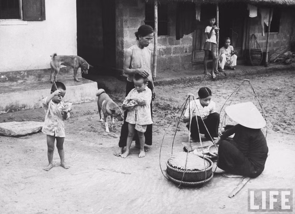 Người bán gạo rong bán hàng tại sân nhà một gia đình nông thôn.