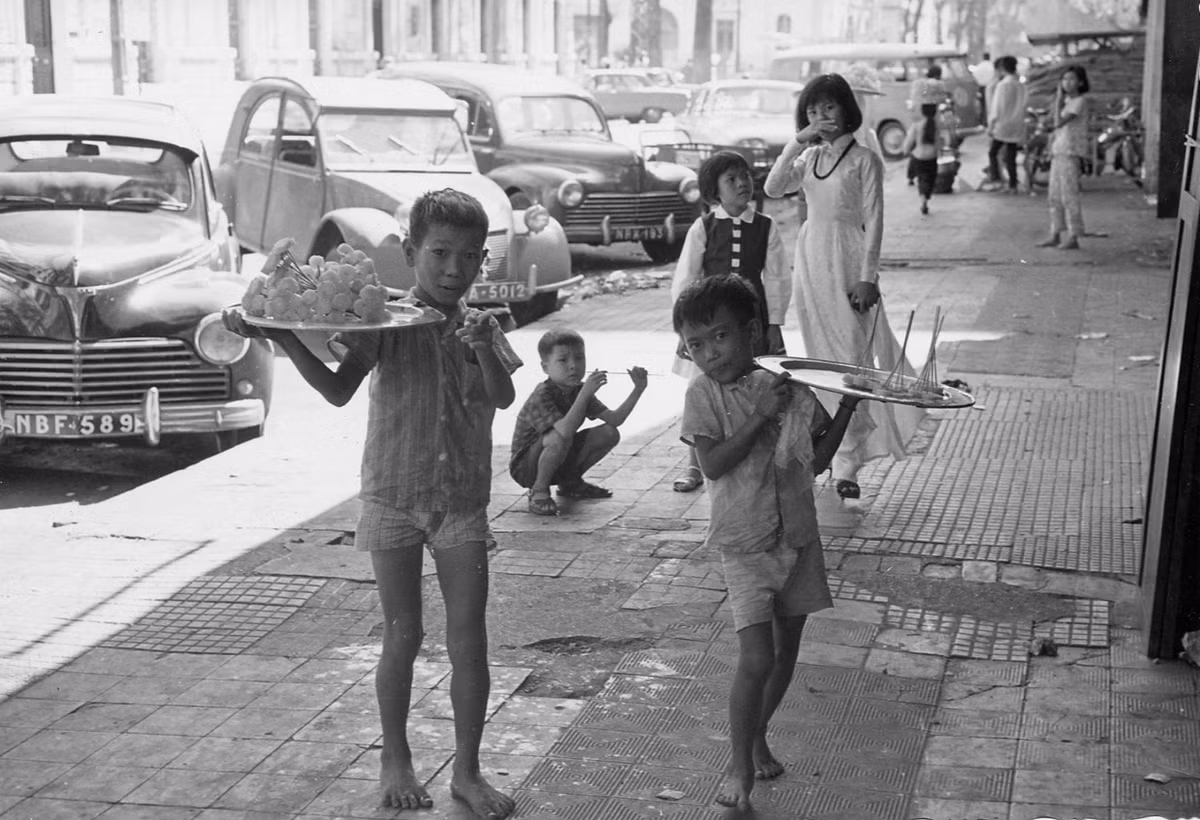 Hai chú bé bán mía ghim trên đường Ngô Đức Kế, nhìn về đại lộ Nguyễn Huệ, 1966. Ảnh: Donald F. Harrison Collection.