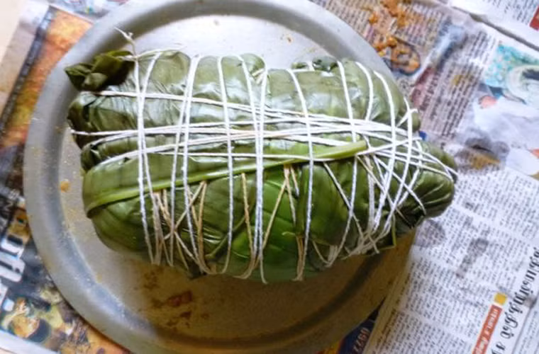 Dùng lá sen rửa sạch bọc kín gà. Tuyệt đối không để hở bất kỳ phần nào rồi dùng dây quấn lại.