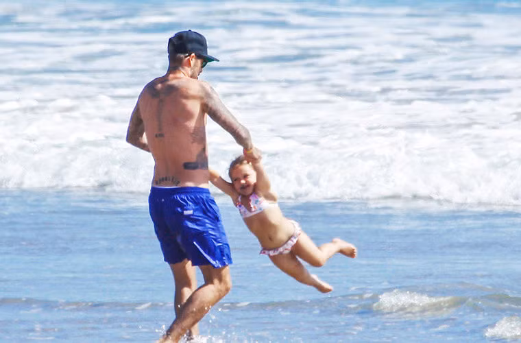 Mặc bộ bikini hoa xinh xắn, Harper Seven Beckham tung tăng cùng bố trên bãi biển Malibu, California.