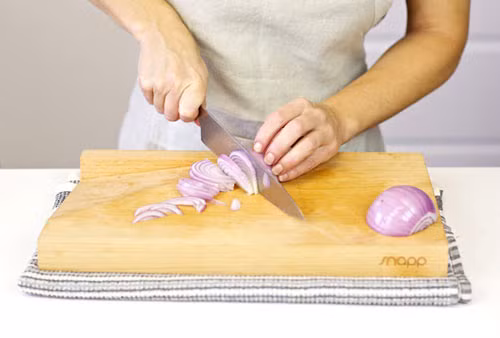 Dùng hành tây. Có một cách đơn giản hơn là dùng hành tây chùi thớt vài lần rồi rửa lại với nước nóng