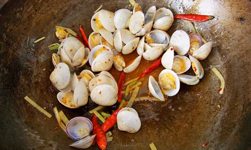 Bước 6: Đổ ngao vào xào chung, cho một bát nước dùng đã được hòa với giấm và đường vào đảo đều, đến khi thấy mùi thơm tỏa ra thì cho ớt vào.