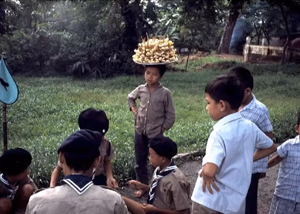 Cậu bé bán mía ghim nhìn những bạn bằng trang lứa đang vui chơi.