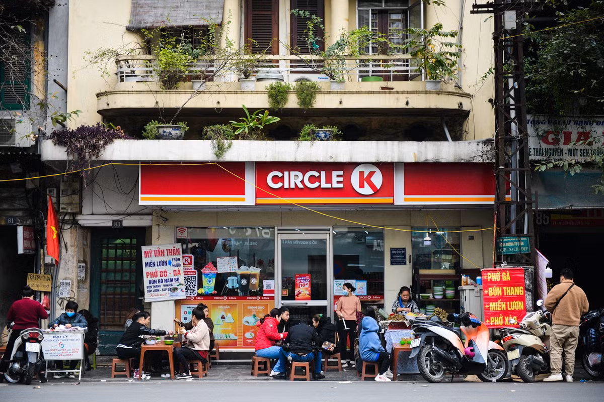 Phần vỉa hè ít ỏi phía trước một cửa hàng tiện lợi cũng được một gánh bún, phở bày kín bàn ghế.