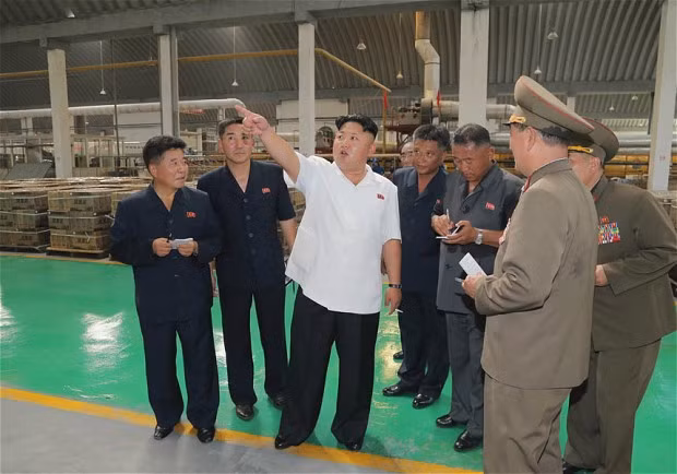 Chủ tịch Kim Jong-un (áo trắng) đang thị sát một đơn vị sản xuất trong quân đội.