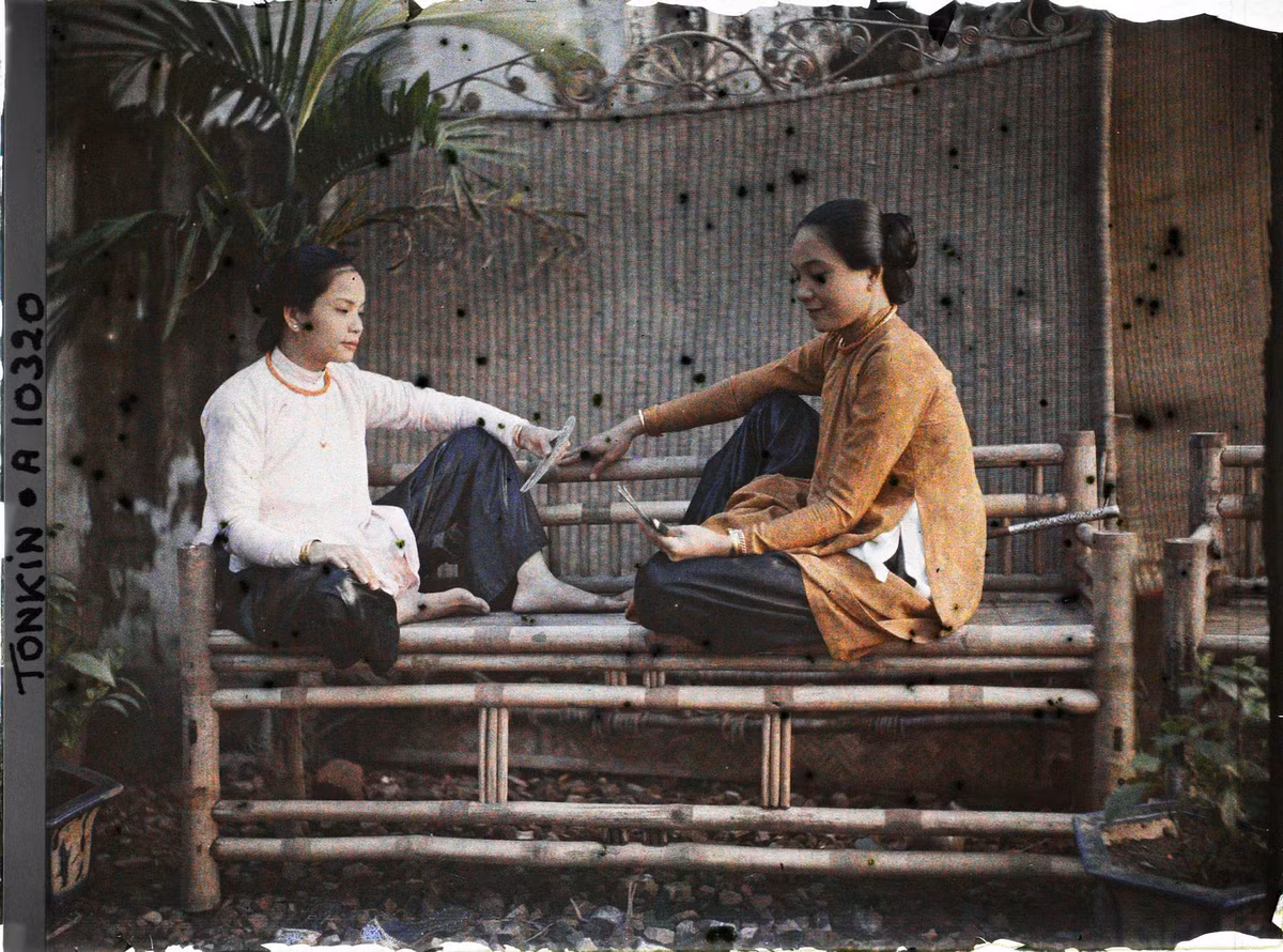 Hai người đẹp Sài Gòn ngồi chơi bài trên ghế tre.