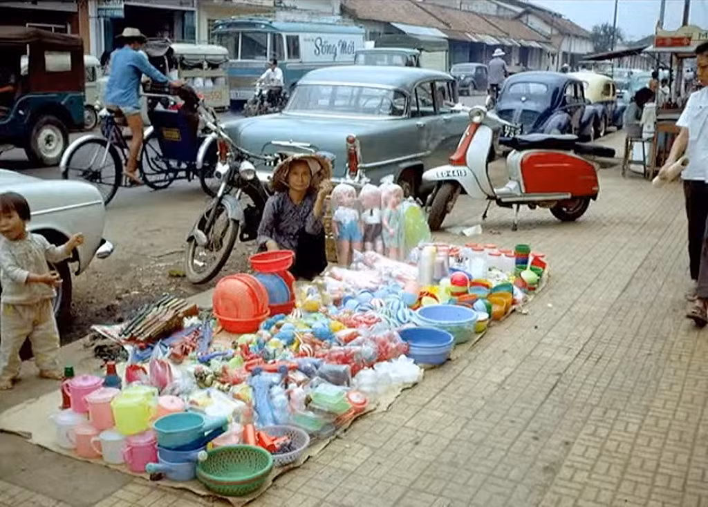 Cụ bà bán búp bê và đồ gia dụng bằng nhựa trên hè đường Phạm Ngũ Lão.