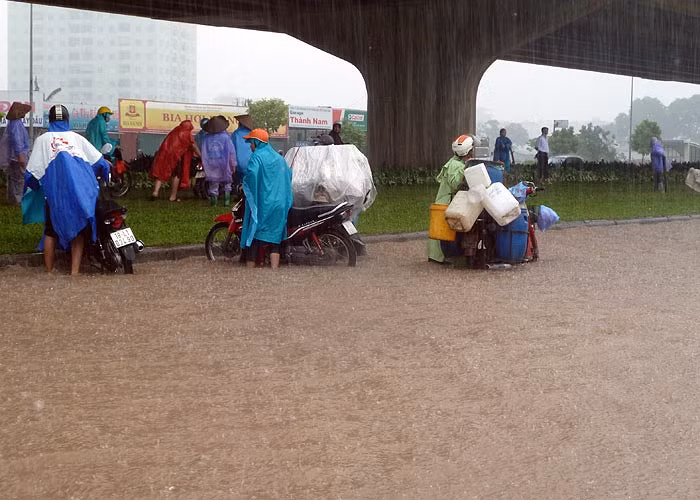 Hàng trăm xe máy bị chết máy phải bê, dắt lên vỉa hè để sửa.