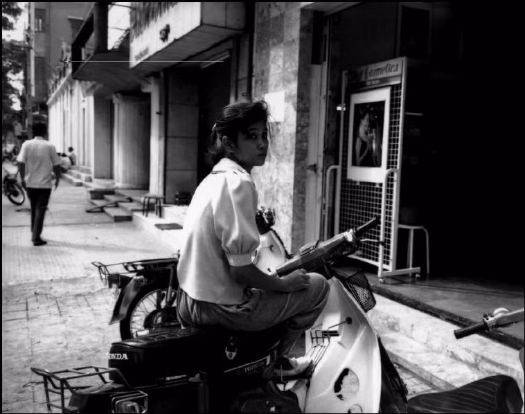 Một cô gái ngồi trên chiếc Honda Cub 82 ở TP HCM.