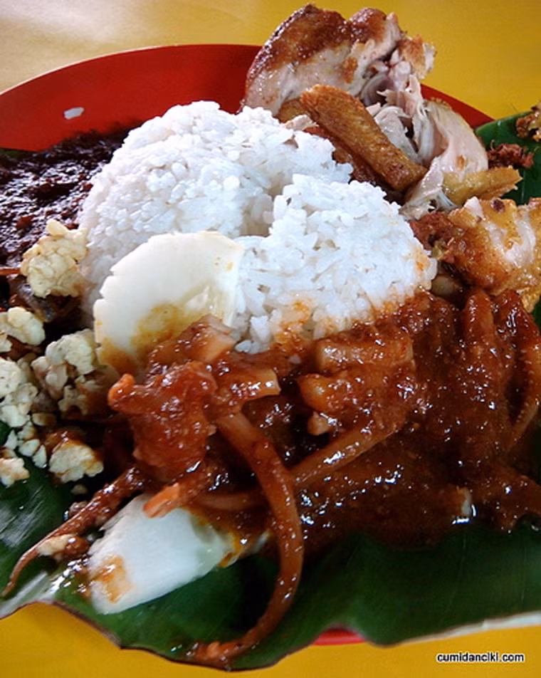 Nasi Lemak. Nasi Lemak là món truyền thống được chế biến bằng cách nấu gạo chung với nước cốt dừa. Nasi Lemak tuyệt ngon khi được thưởng thức kèm dưa leo, cá con chiên, lạc rang, sốt ớt, trứng luộc, rau cải hoặc thịt bò kho…