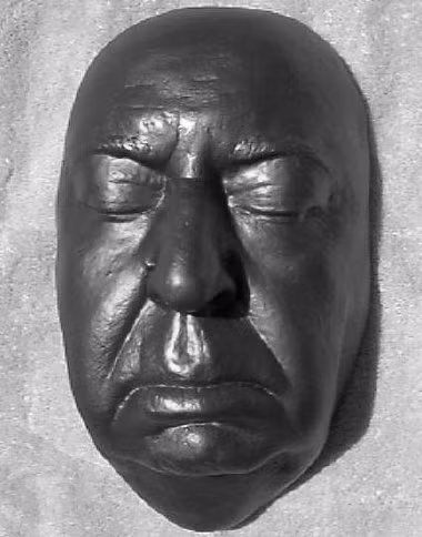 HITCHCOCK (1899-1980), nhà đạo diễn người Anh đã làm nhiều phim tâm lí kinh dị về cái chết trong suốt sự nghiệp 60 năm, nhiều phim trở thành kinh điển. Vị Vua Trinh thám này cuối củng cũng được bất tử hoá bằng chiếc mặt nạ của chính mình trông rất hợp với cảnh trong nhà trọ Bates Motel (Psycho). Ông chết vì bệnh thận, căn bệnh của nhiều khán giả của ông: nín thở, nín đái và sợ đến “tè ra quần” .
