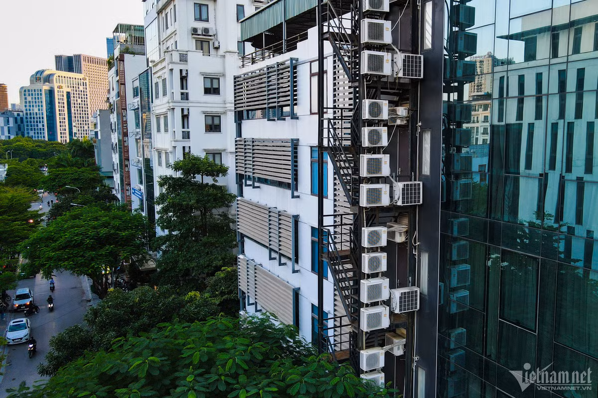 Một tòa nhà cao tầng được thiết kế cửa kính kín có khu vực thoát hiểm riêng. Cục nóng điều hòa được treo lên khu vực thang để đảm bảo tính thẩm mỹ cho tòa văn phòng.