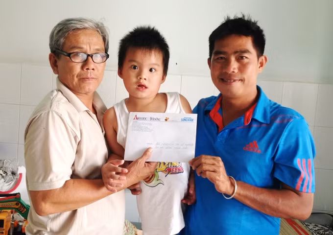 PV Báo điện tử Kiến Thức đang trao cho ông Nguyễn Thành Tâm số tiền của 3 bạn đọc giúp đỡ cháu Thiên Bảo.