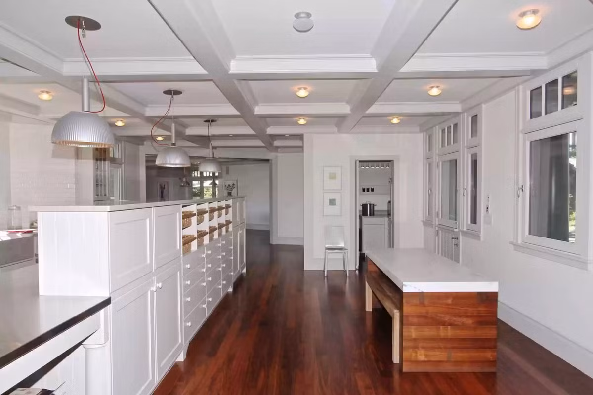 Phòng bếp ốp sàn gỗ màu nâu và phần trần gỗ sơn trắng. Ảnh: Realtor.