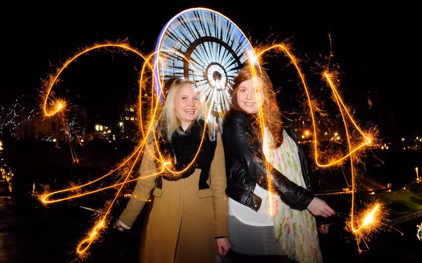 Hai cô gái Anh xinh đẹp, Catriona Ross, 25 tuổi ở Edinburgh (phải) và Jennifer Wallace (cùng tuổi) ở Aberdeen cũng như rất nhiều người khác tụ tập đón năm mới tại Công viên Princes Street.