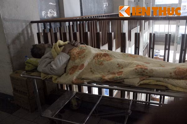 Một người nhà bệnh nhân đã lớn tuổi "may mắn" kiếm được một băng ca trống ở góc hành lang, bèn "chiếm cứ" và tranh thủ chợp mắt.