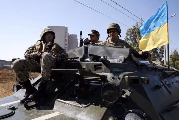 Thành viên tiểu đoàn vũ trang tình nguyện Azov ngồi trên xe bọc thép gần trạm kiểm soát ở Mariupol ngày 5/9.