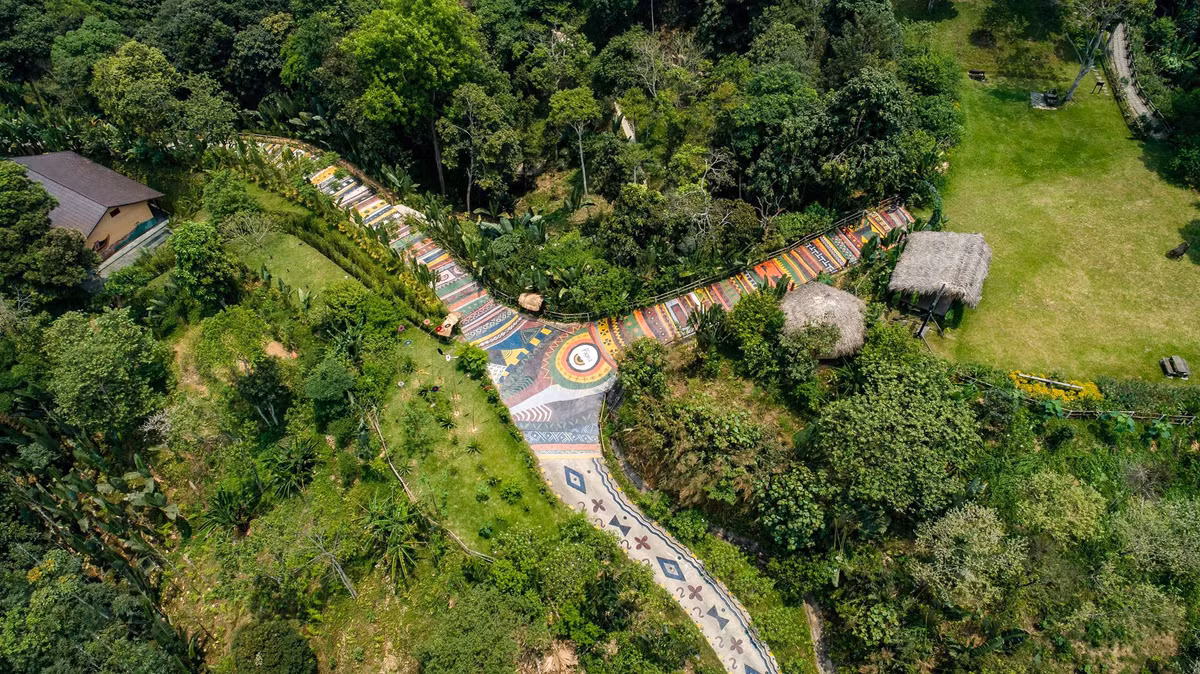 Xã Yên Định, huyện Bắc Mê (Hà Giang) là nơi có con đường thổ cẩm dài kỷ lục Việt Nam. Con đường thuộc một khu resort, trải dài 1.700 m trên triền đồi, được người dân địa phương trang trí họa tiết thổ cẩm nhiều màu và hình ảnh đặc trưng của văn hóa vùng cao. Ảnh: P'apiu.