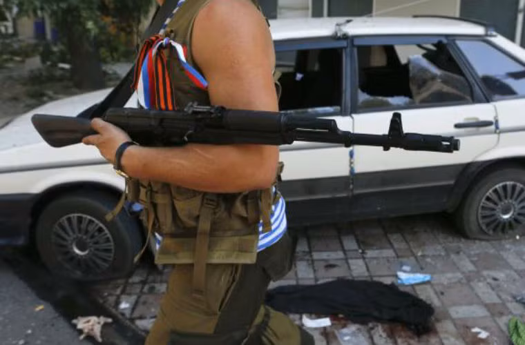 Dân quân Donetsk bên cạnh chiếc xe bị hư hại do pháo kích của Quân đội Ukraine.