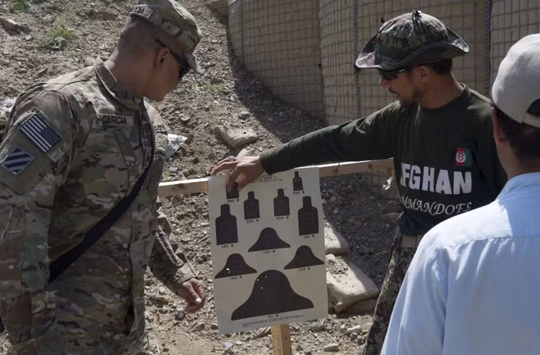 Binh sĩ Mỹ hướng dẫn thành viên đội đặc nhiệm của Quân đội Afghanistan sử dụng súng máy tự động M249. Đội Commando của Quân đội Afghanistan có khoảng 600 binh sĩ, đóng quân tại căn cứ Kandaks.
