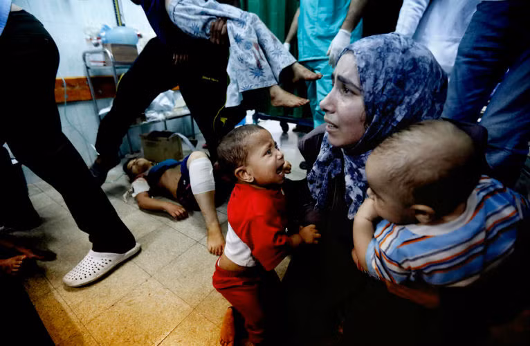 Một người mẹ trẻ ôm 2 đứa con trong bệnh viện ở dải Gaza sau cuộc pháo kích của Israel.